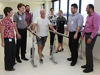St Stephen's rehabilitation team watch as Dale Barwise-Smith tries out the new gym equipment.