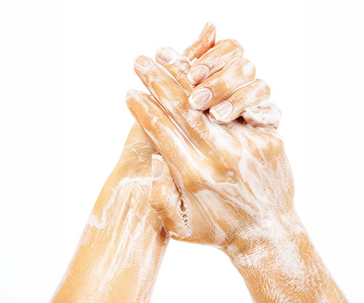 A close-up of a woman’s soapy hands as she practises good hand hygiene.